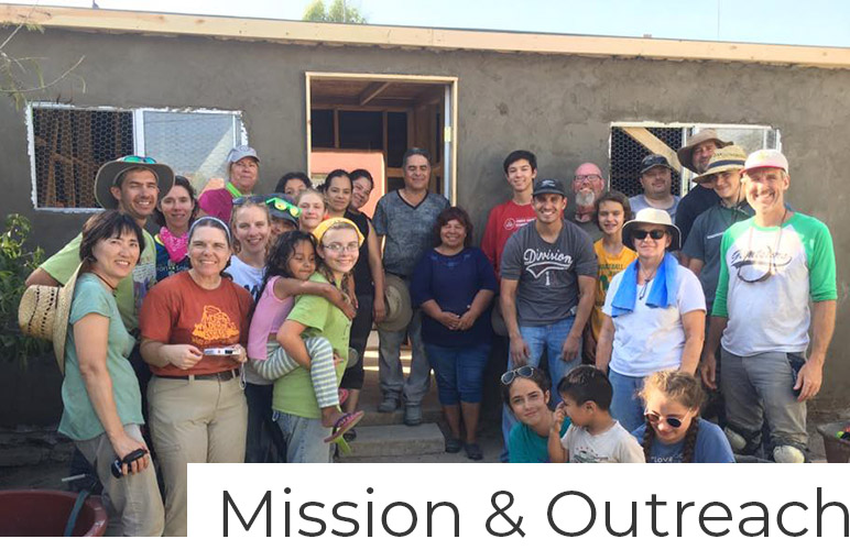mission and outreach volunteers in front of a house they built in mexico